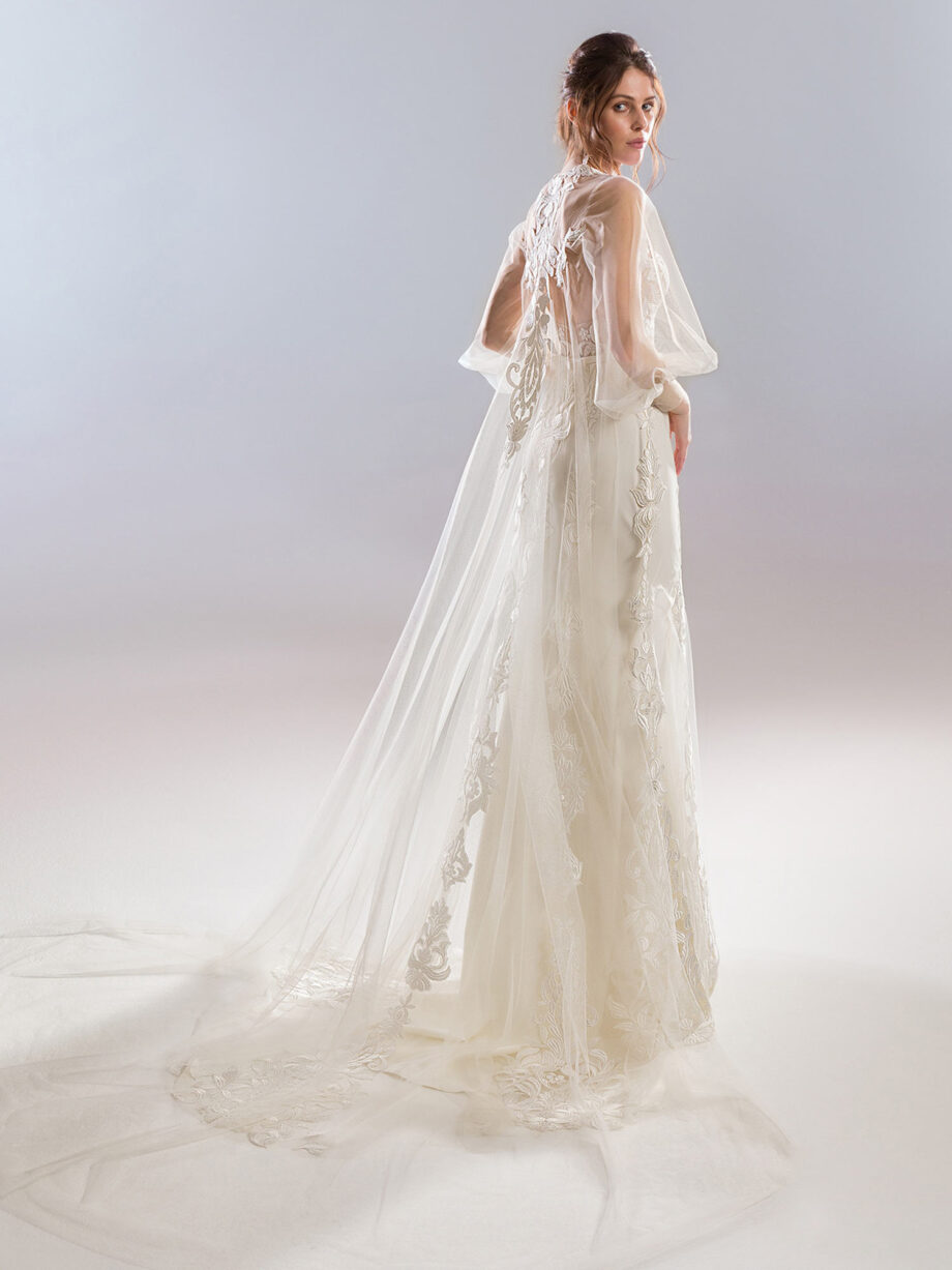 Back view of a strapless wedding dress in ivory-nude with a fitted lace bodice, complemented by a detachable tulle cape with bishop sleeves and lace embroidery, showcased at Papilio Boutique's sample sale in Toronto.