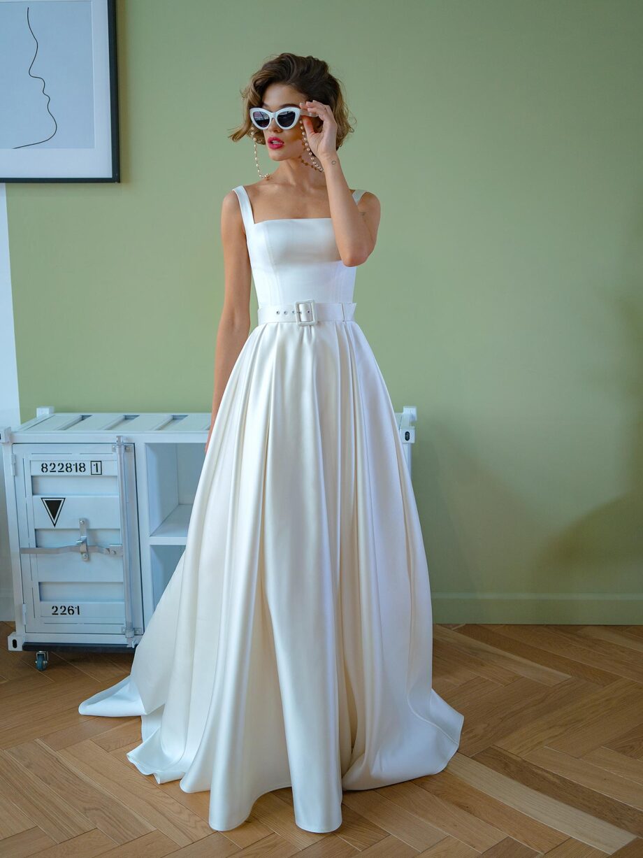 Minimalist satin ball gown with square neckline and detachable belt, showcased at Papilio Boutique bridal store in Toronto.