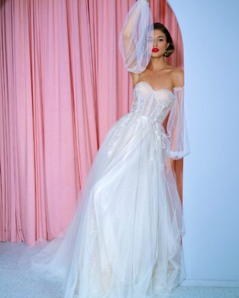 Front view of an A-line wedding dress with detachable puff sleeves, featuring a corset bodice and embroidered details. Dress by Papilio Boutique bridal store in Toronto.