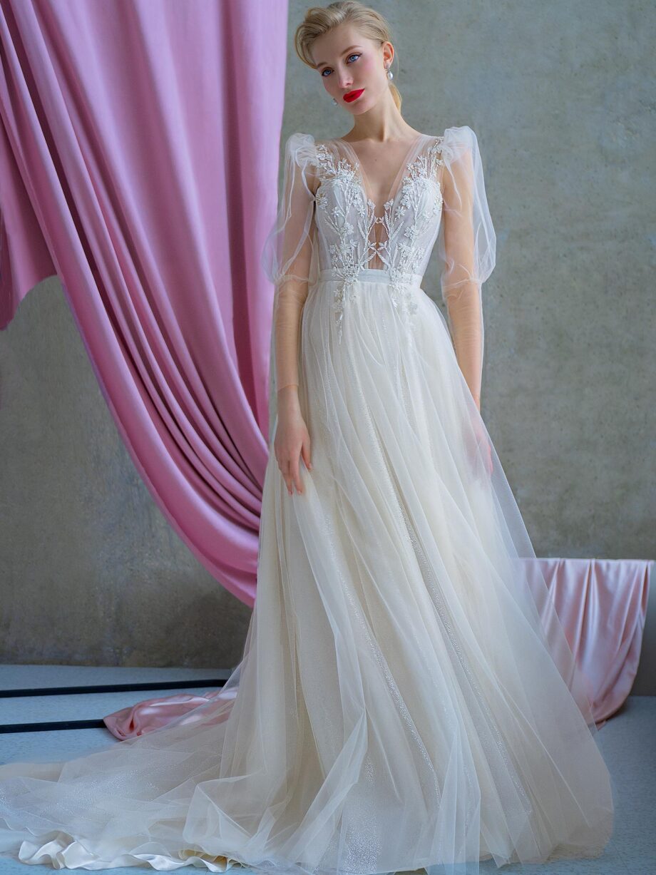 Romantic wedding gown with puff sleeves, plunging bodice, and sparkling tulle skirt, available at Papilio Boutique.