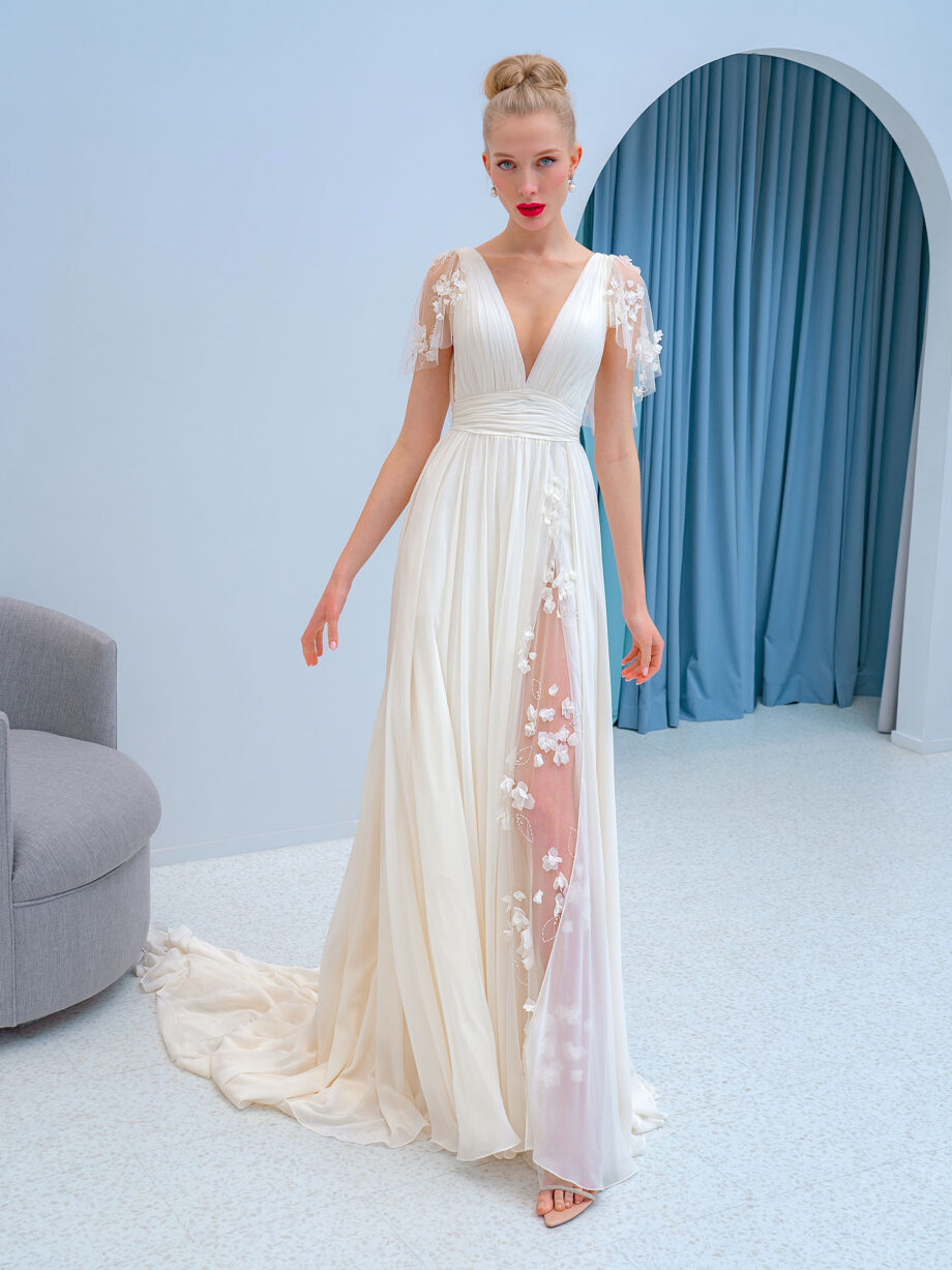 Elegant chiffon dress with 3D floral décor, featuring flutter sleeves, a draped bodice, and an open back. Available at Papilio Boutique in Toronto.