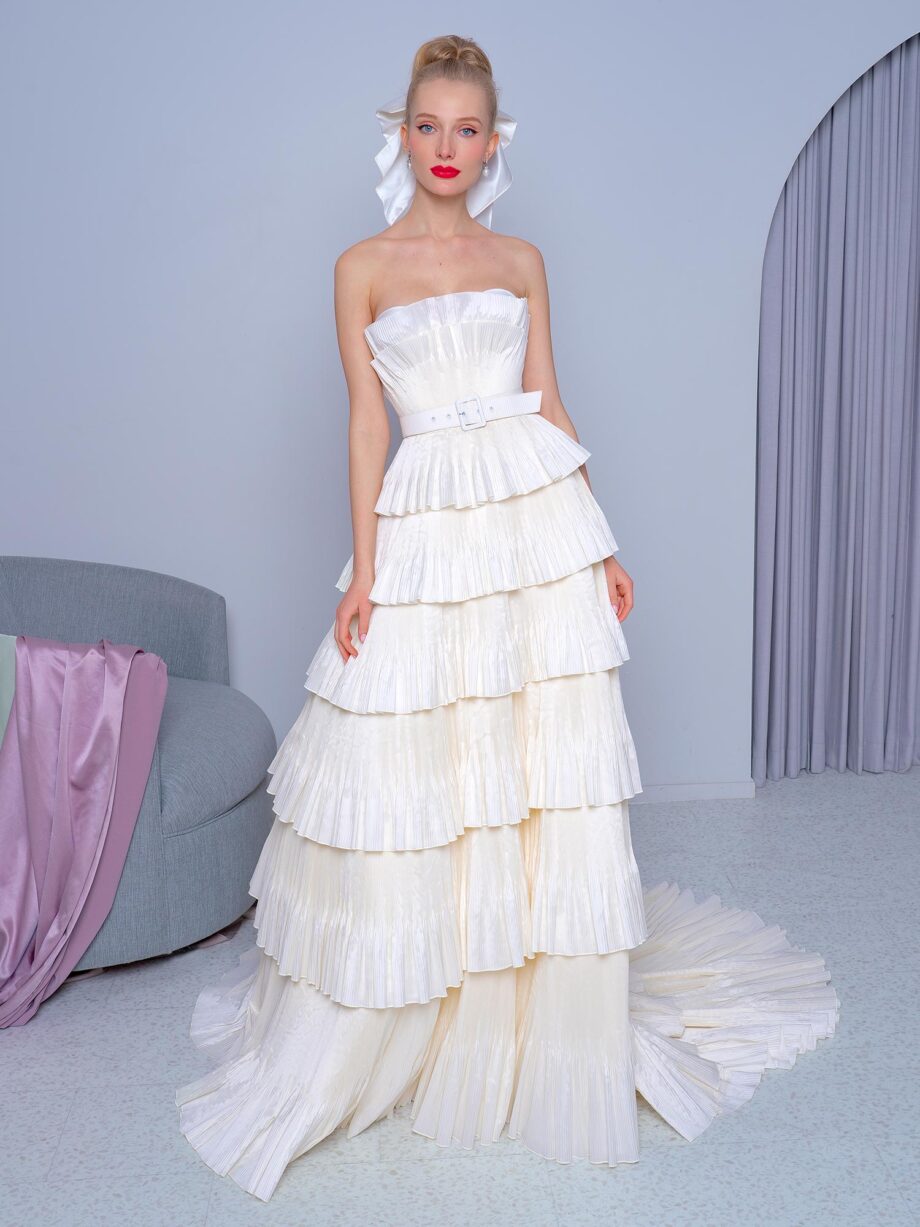 Strapless tiered A-line wedding dress with pleated taffeta and a lace-up bodice, featuring an adjustable belt, available at Papilio Boutique.