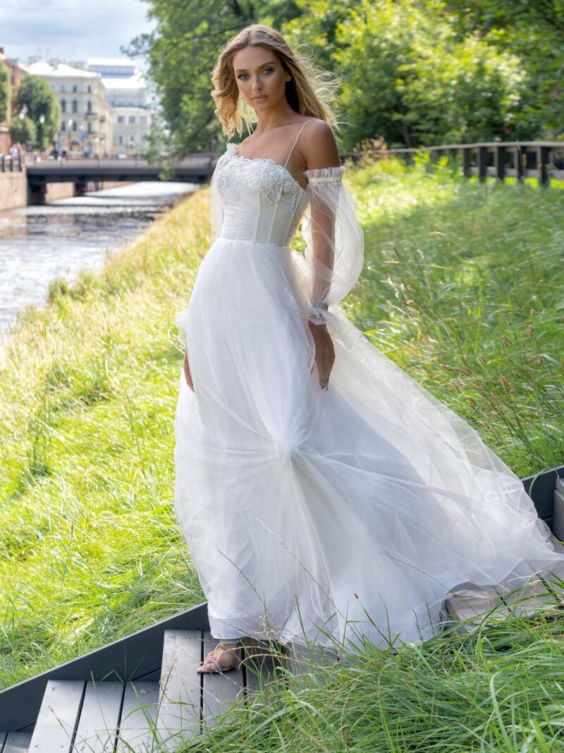 Ball gown wedding dress with asymmetric neckline and long sleeves