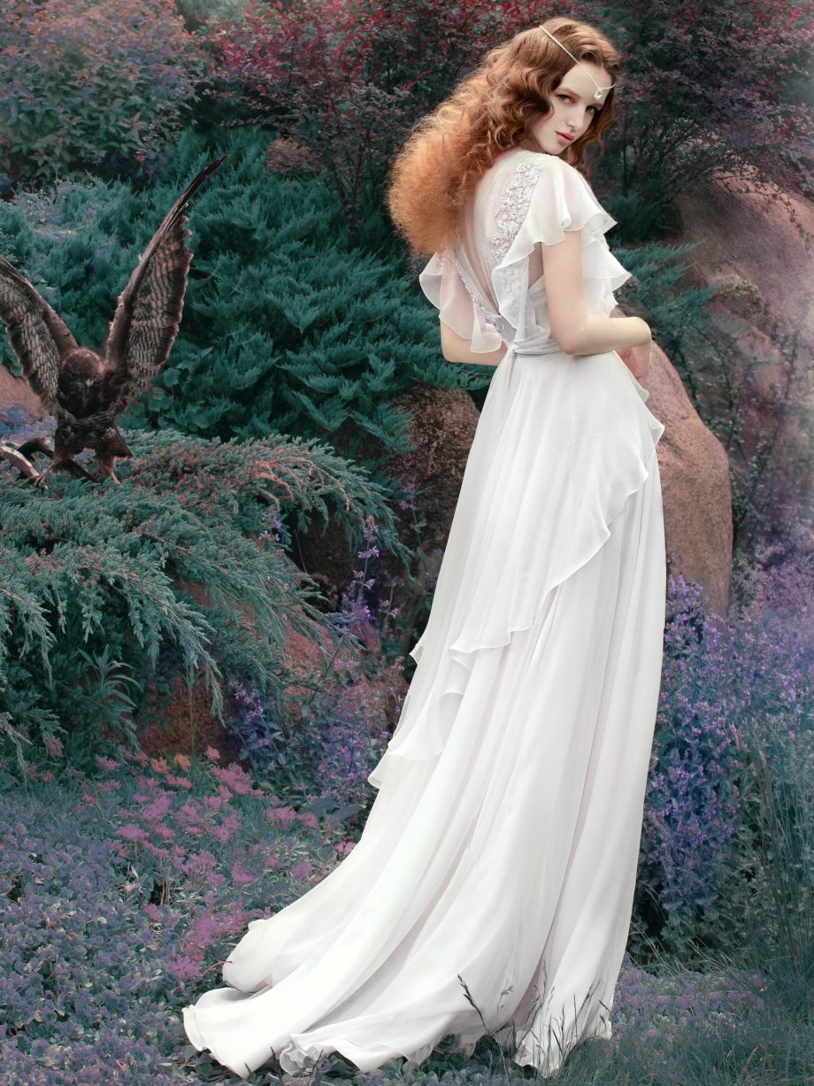 A side view of a bride in a flowing bohemian sheath wedding dress, featuring layered fabric and a deep lace back, captured in natural light. A stunning option for bohemian wedding dresses Toronto