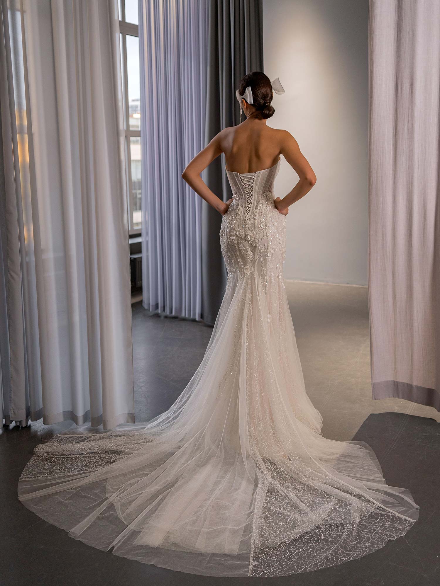 fit and flare wedding dress with basque waist, semi-sheer bodice, boning, and extended tulle train by Papilio Boutique bridal store in Toronto