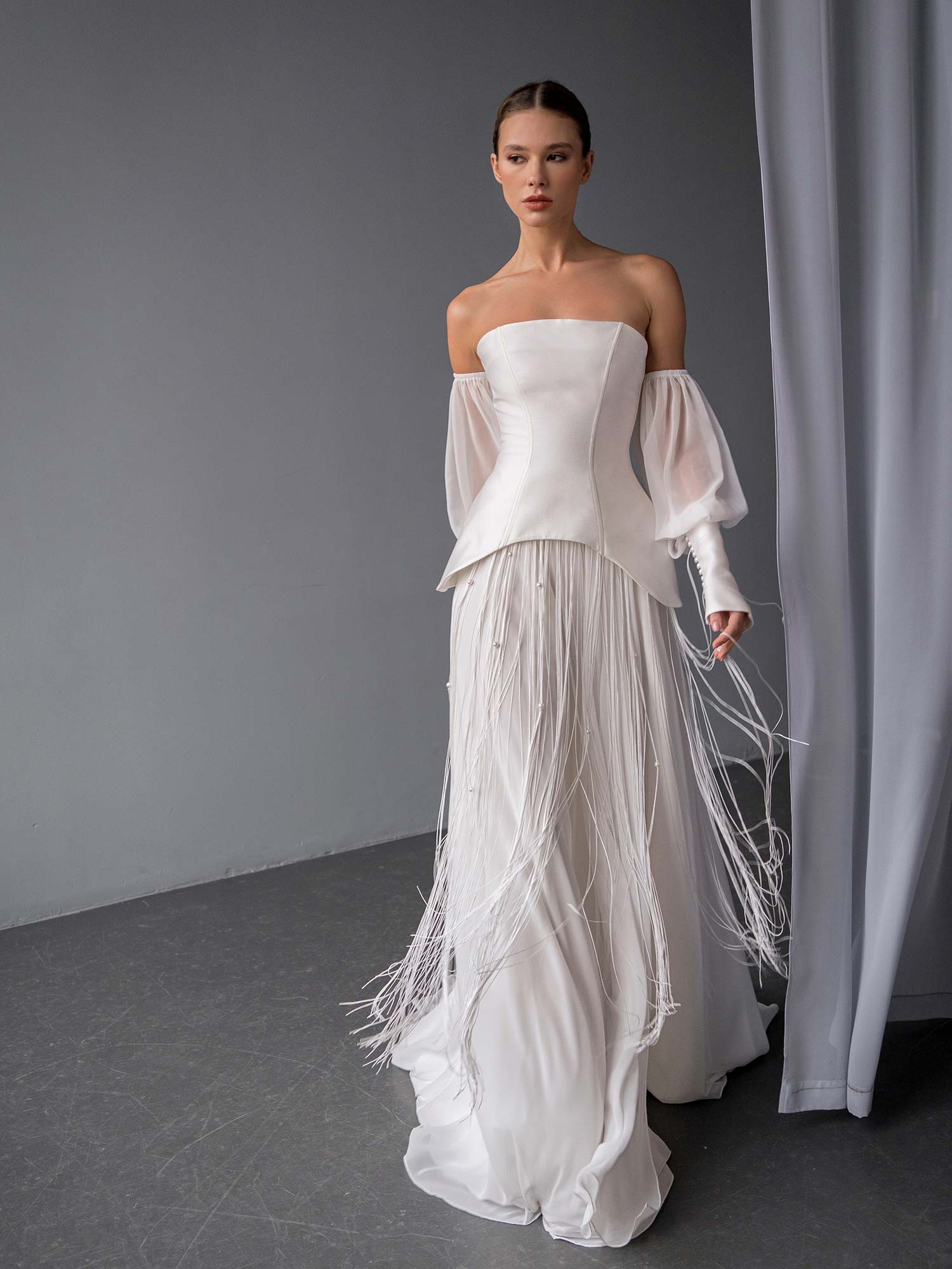 elegant two piece wedding dress with corset top and beaded skirt by Papilio Boutique in Toronto, showing high slit and beaded fringe details
