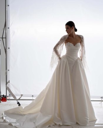 Structured satin ballgown wedding dress with cape by Papilio, photographed in studio, couture satin skirt and beaded cape — Toronto bridal shop.