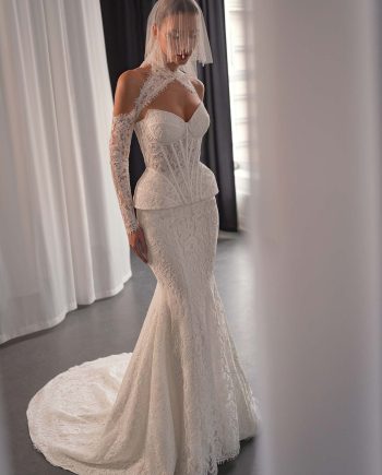 Model wearing a lace two-piece wedding dress with a semi-sheer corset and fitted lace skirt, photographed inside Papilio Boutique bridal store in Toronto.