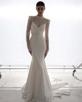 Draped fit and flare wedding dress with long sleeve beaded blouse by Papilio Boutique, shown in a Toronto bridal store.