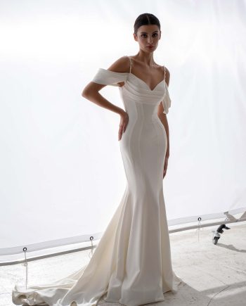 Simple wedding dress with off the shoulder straps and draped bodice by Papilio Boutique, bridal store in Toronto.