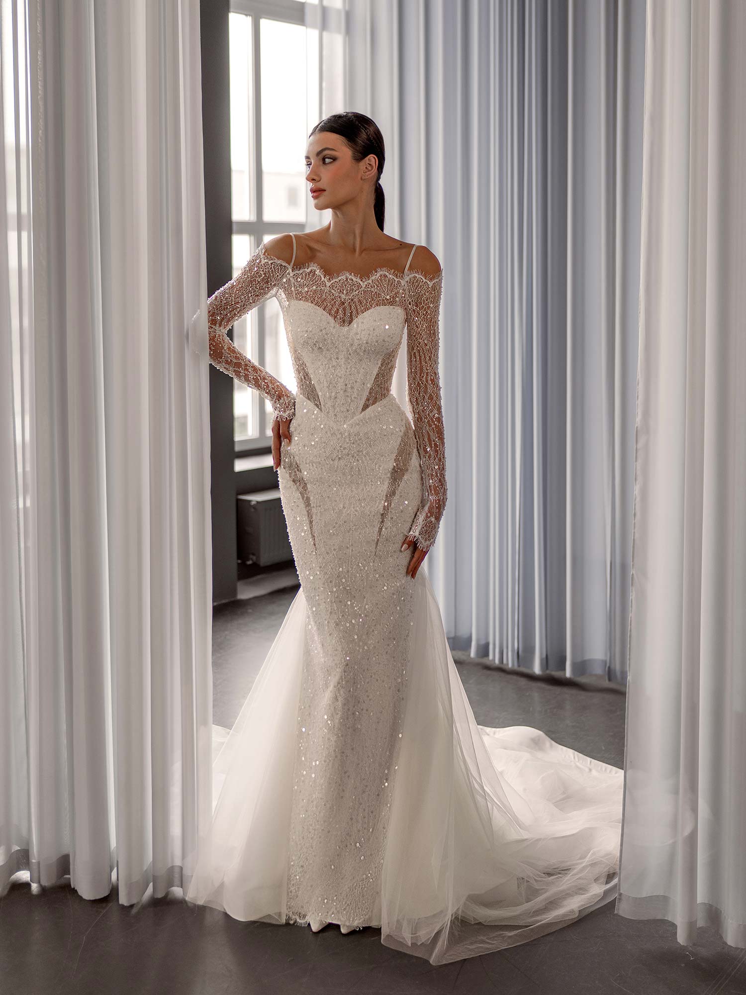 Shimmering off the shoulder wedding dress with long sleeves by Papilio Boutique, fully beaded with a basque waist, from a Toronto bridal store.