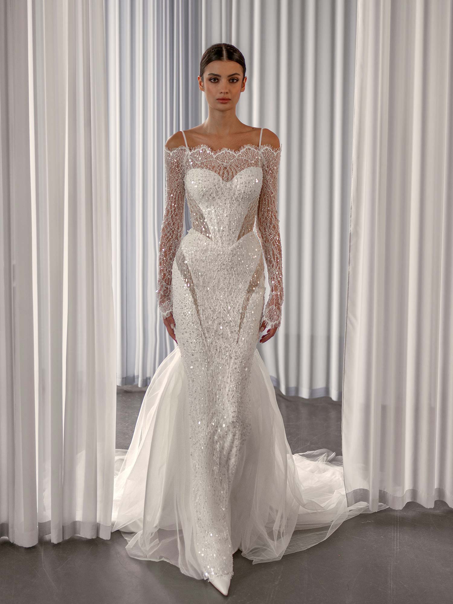 Sparkling off the shoulder wedding dress with long sleeves by Papilio Boutique, with sequins and nude-lined cutouts, from a Toronto bridal shop.