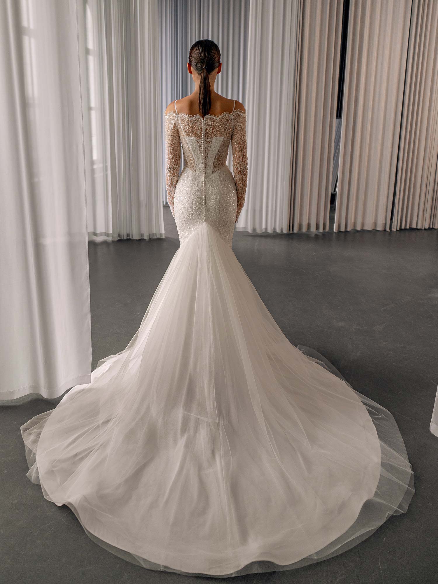 Beaded off the shoulder wedding dress with long sleeves by Papilio Boutique, featuring a tulle flare and fit-and-flare silhouette, from a Toronto bridal store.