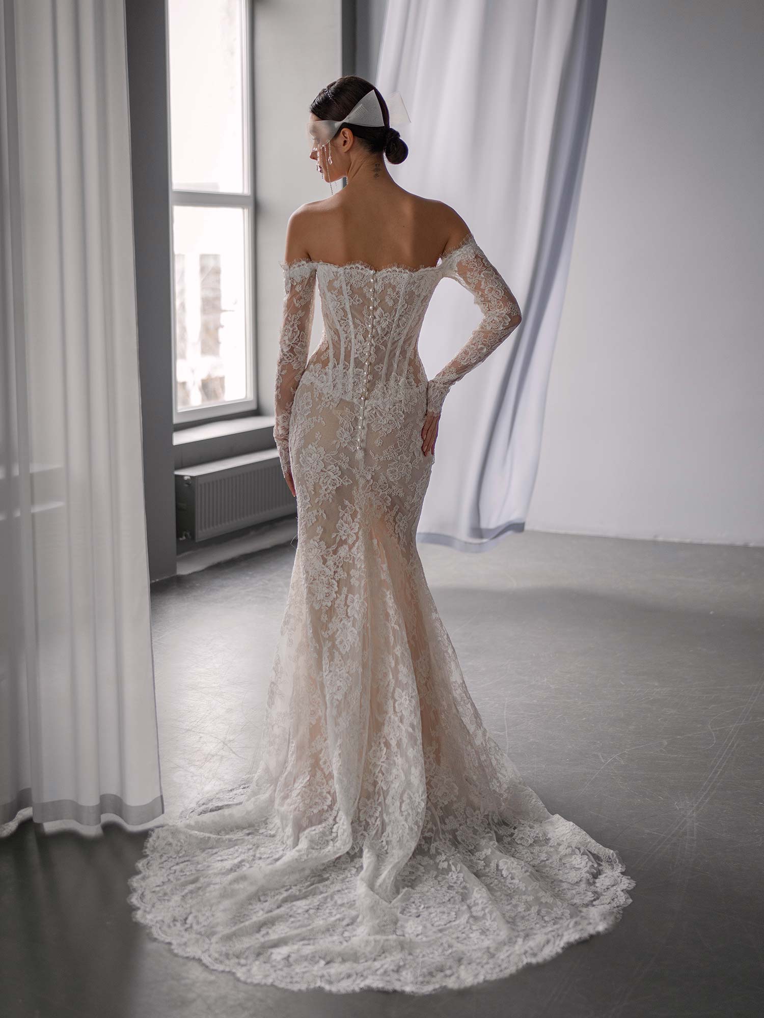 Back view of drop waist fit and flare wedding dress with off the shoulder lace sleeves and scalloped train, BY Papilio Boutique, bridal store in Toronto.